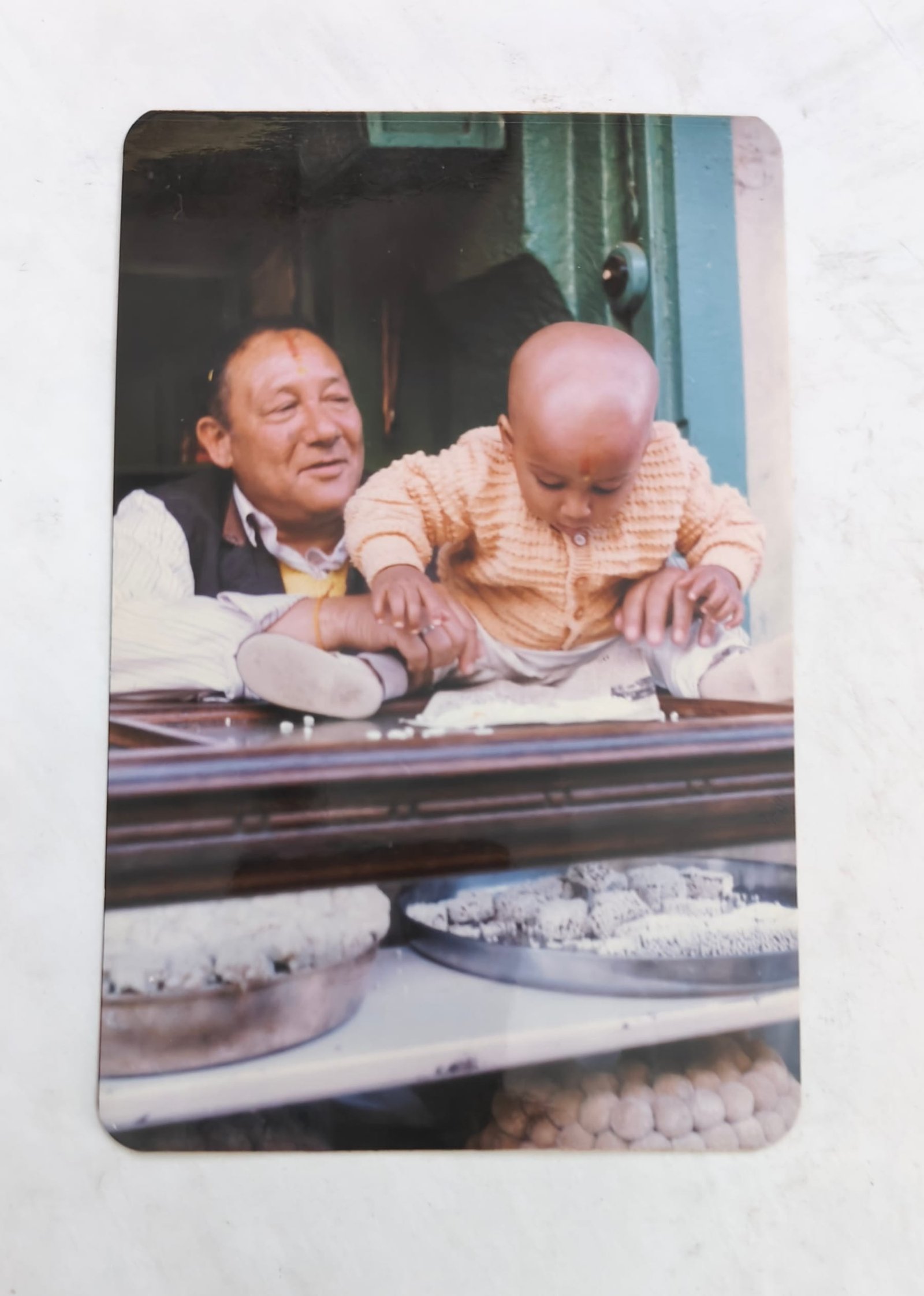 Archive photograph of two men of different generations together behind the shop counter