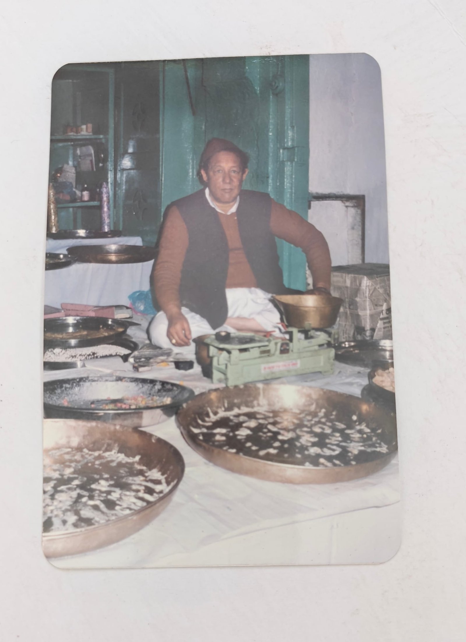 Archive photograph of sweets being weighed on a brass balance at the counter