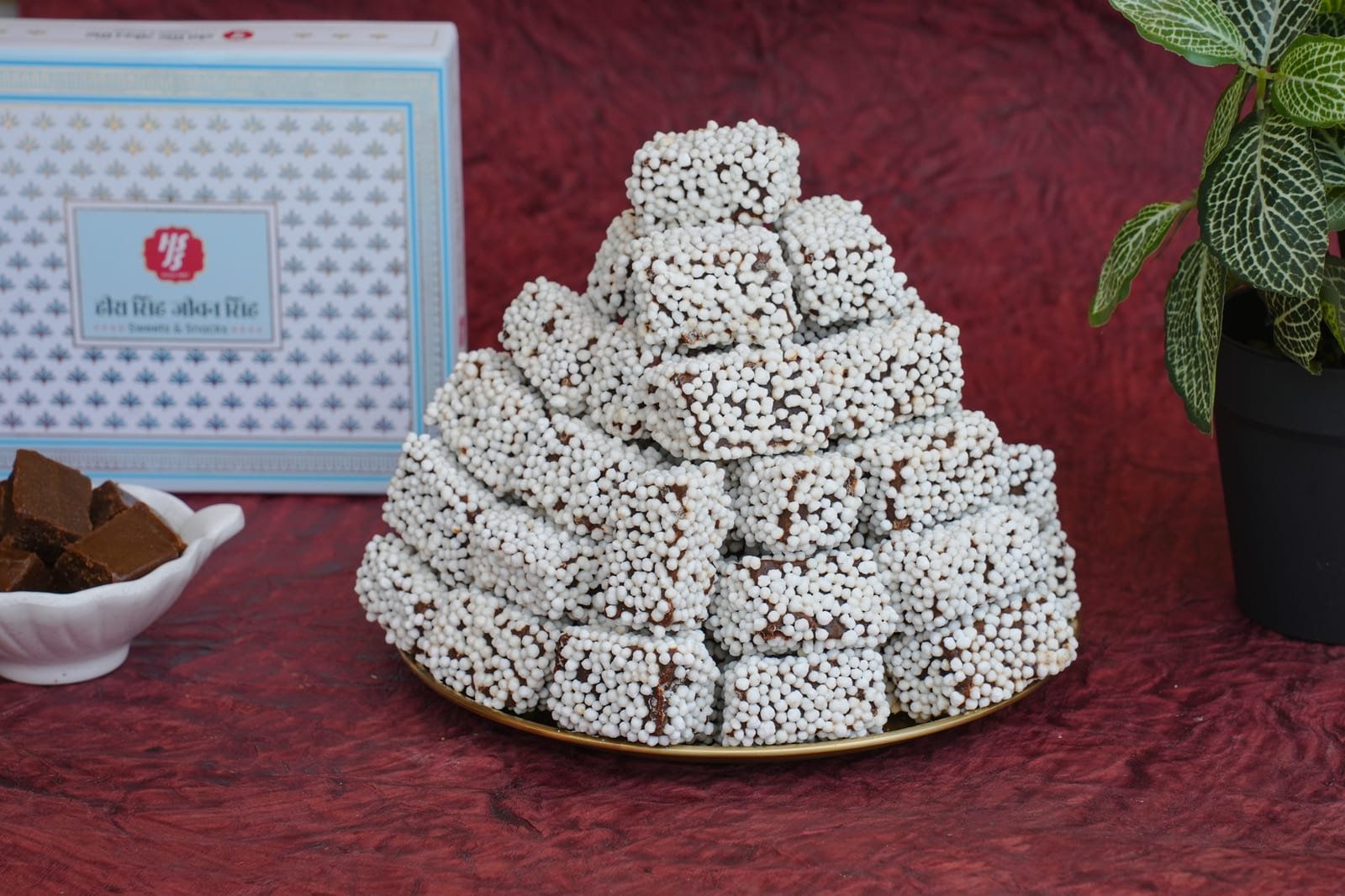A pyramid of bal mithai, dark roasted khoya cubes coated in tiny white sugar pearls