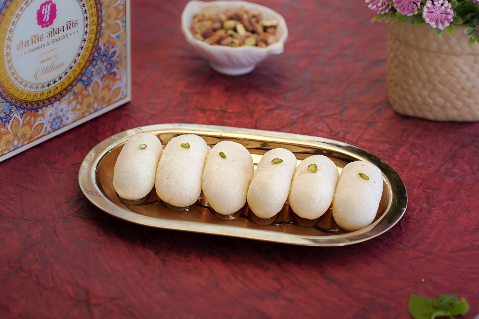 Pale cham cham arranged in a row, each topped with pistachio
