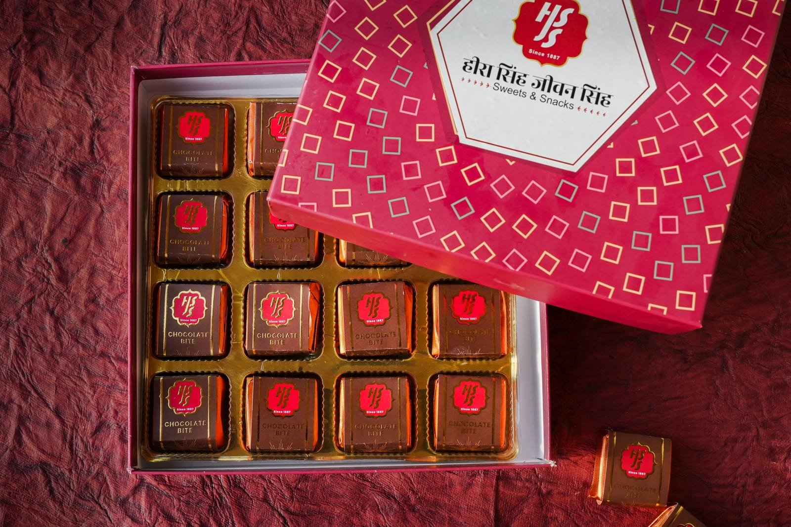 Chocolate bites arranged in a crimson HSJS branded presentation box