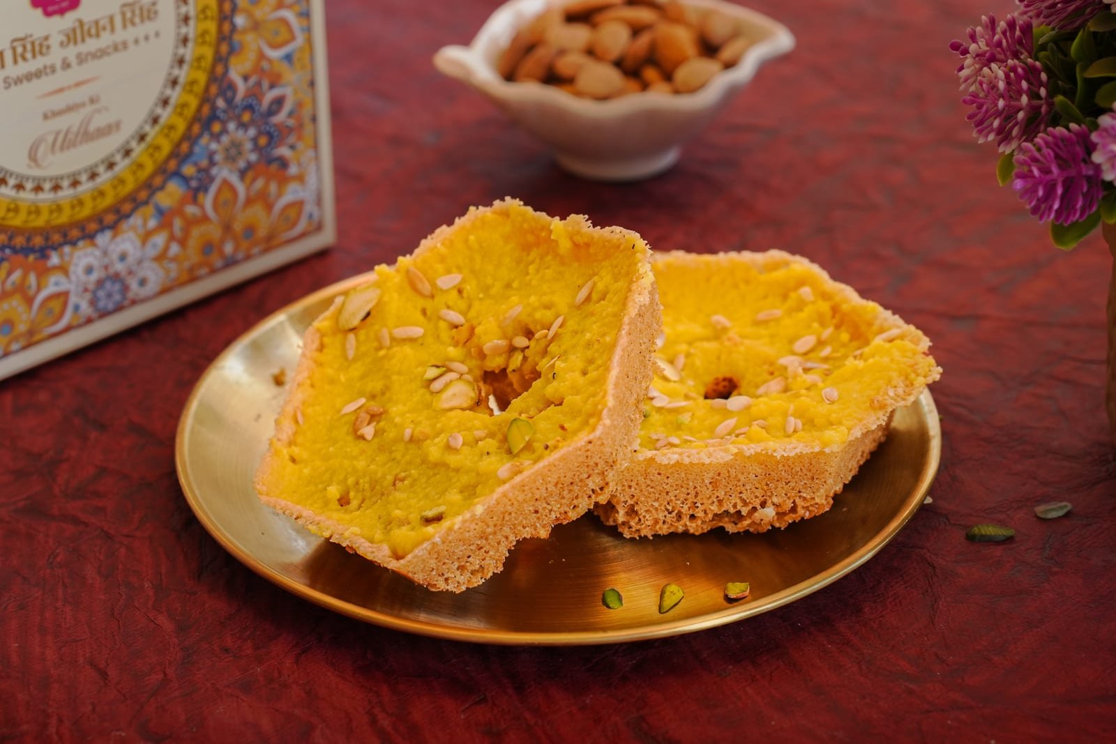 Two golden ghewar discs on a brass plate
