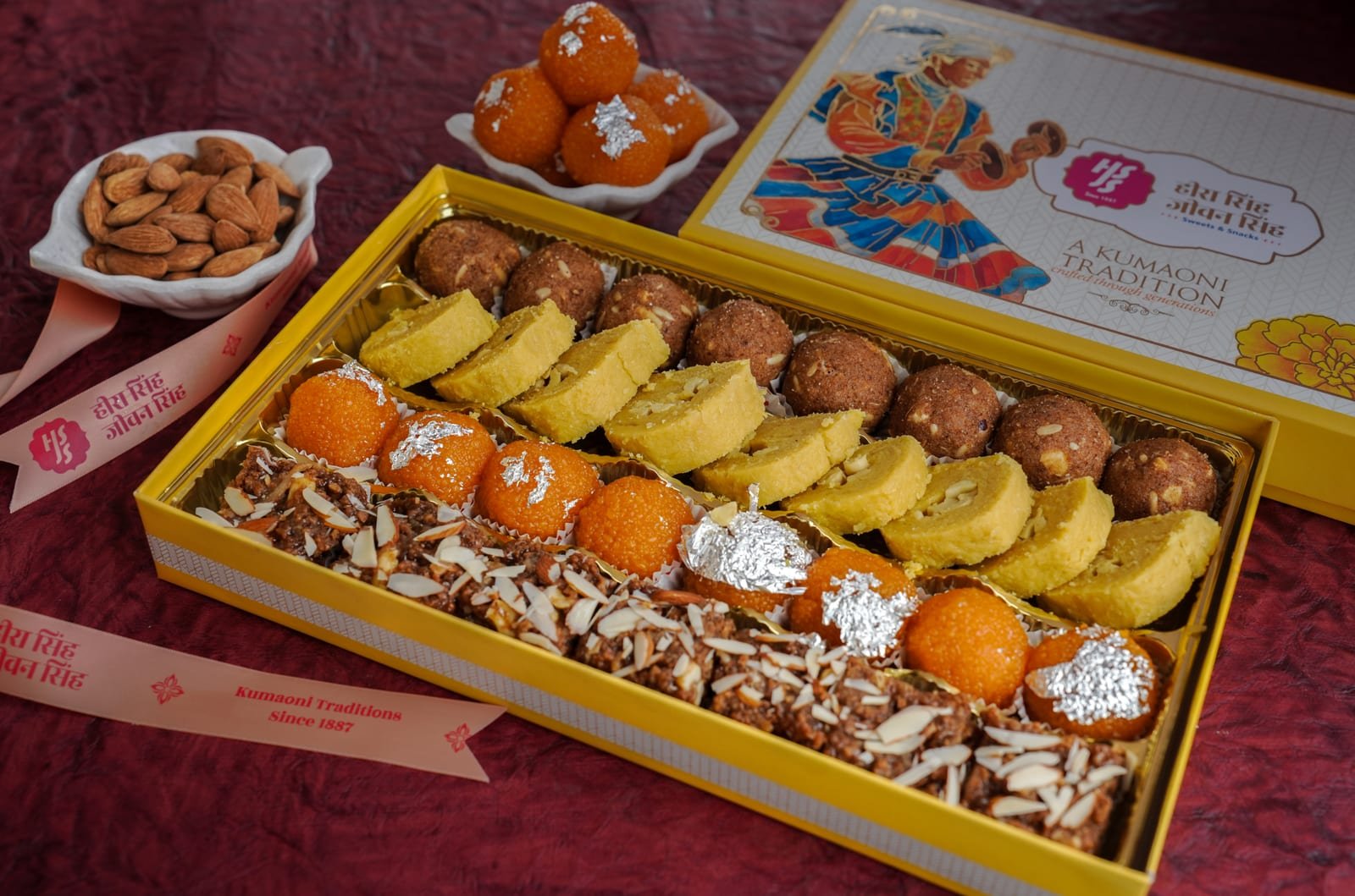 A large presentation box laid out with rows of assorted mithai