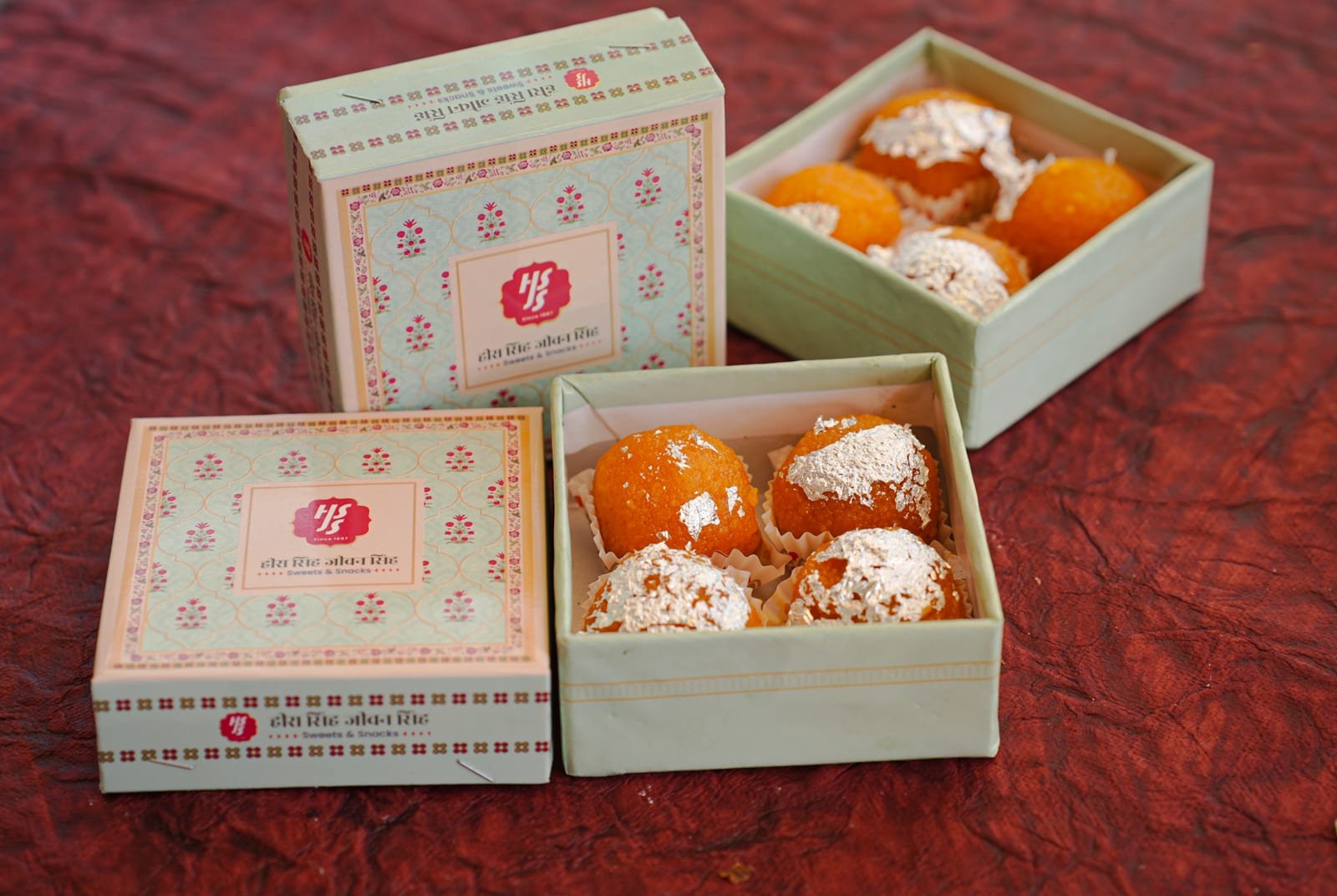 A small pastel gift box holding a few individually placed sweets