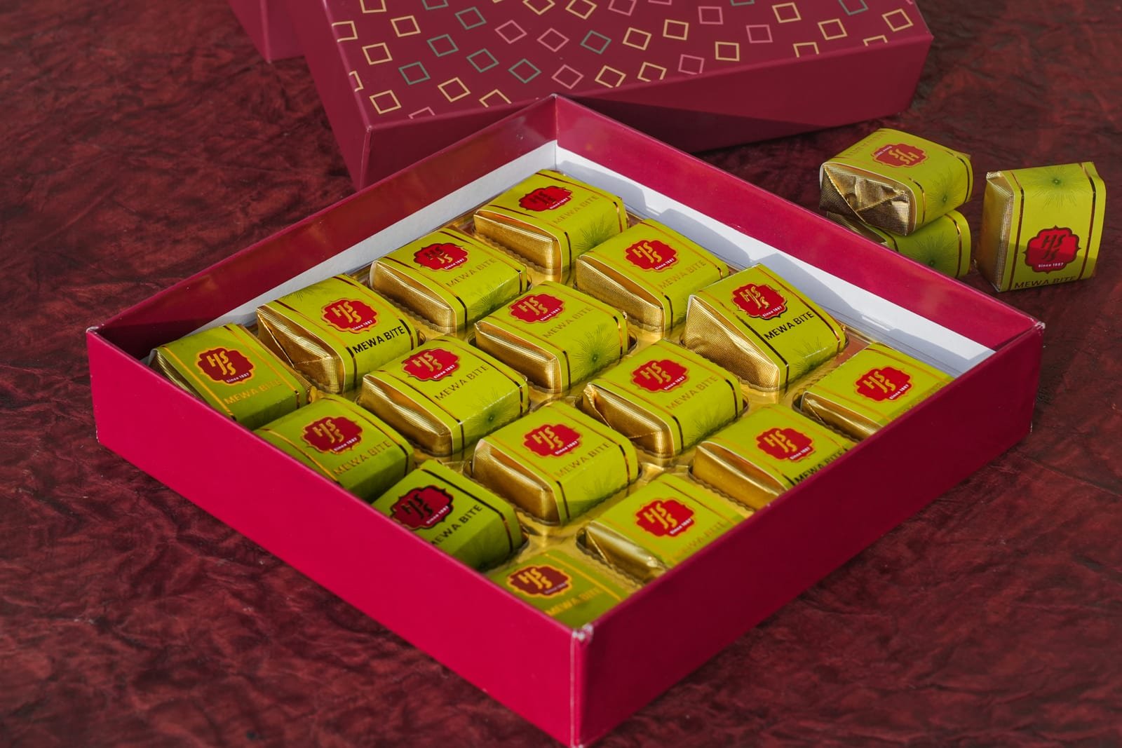 Foil-wrapped mewa bites packed into a green and pink gift box