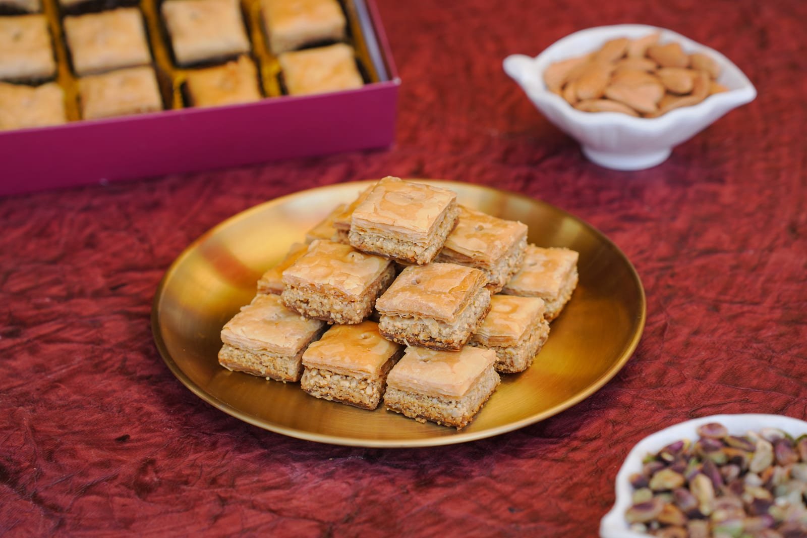 Square-cut baklava arranged on a gold plate